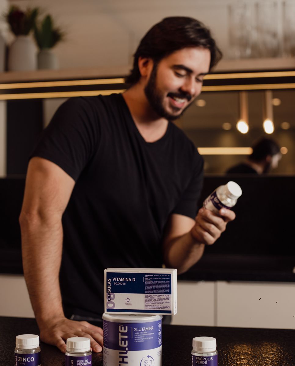 A weary older man at a counter of supplement bottles